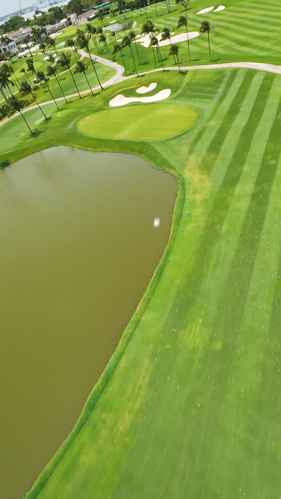 Over the water hazard — the green, the bunkers and the ball in one frame.