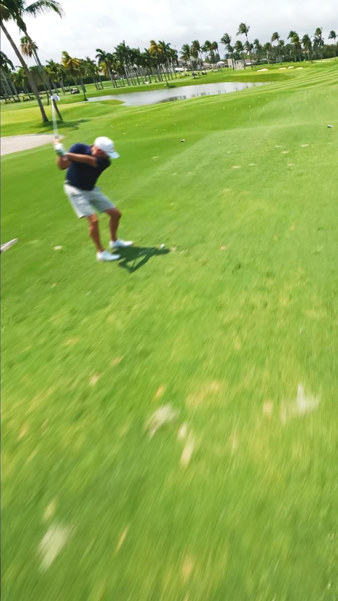 Diving past the golfer at the top of the swing.