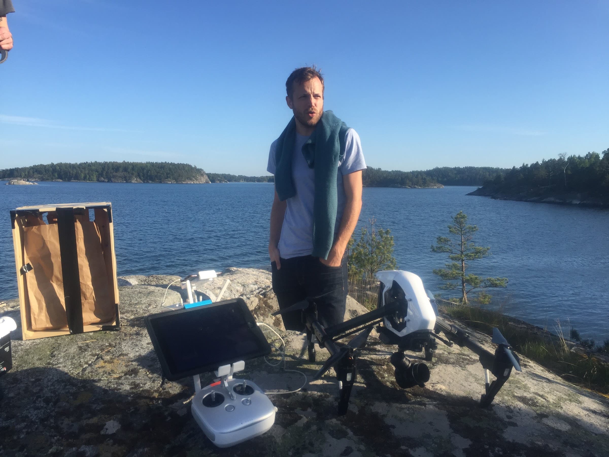 Aerial pilot preparing the drone by the water in the archipelago